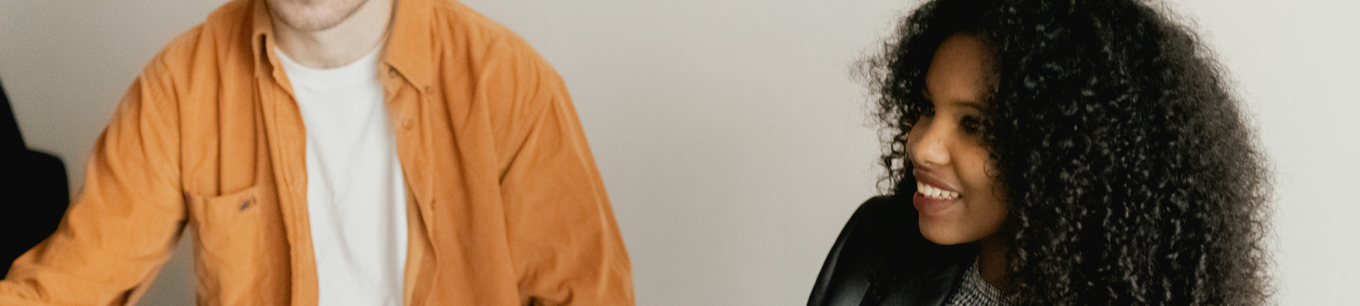 Two individuals engaged in discussion about MSP services procurement while sitting next to each other in a room. Two individuals engaged in discussion about MSP services procurement while sitting next to each other in a room.